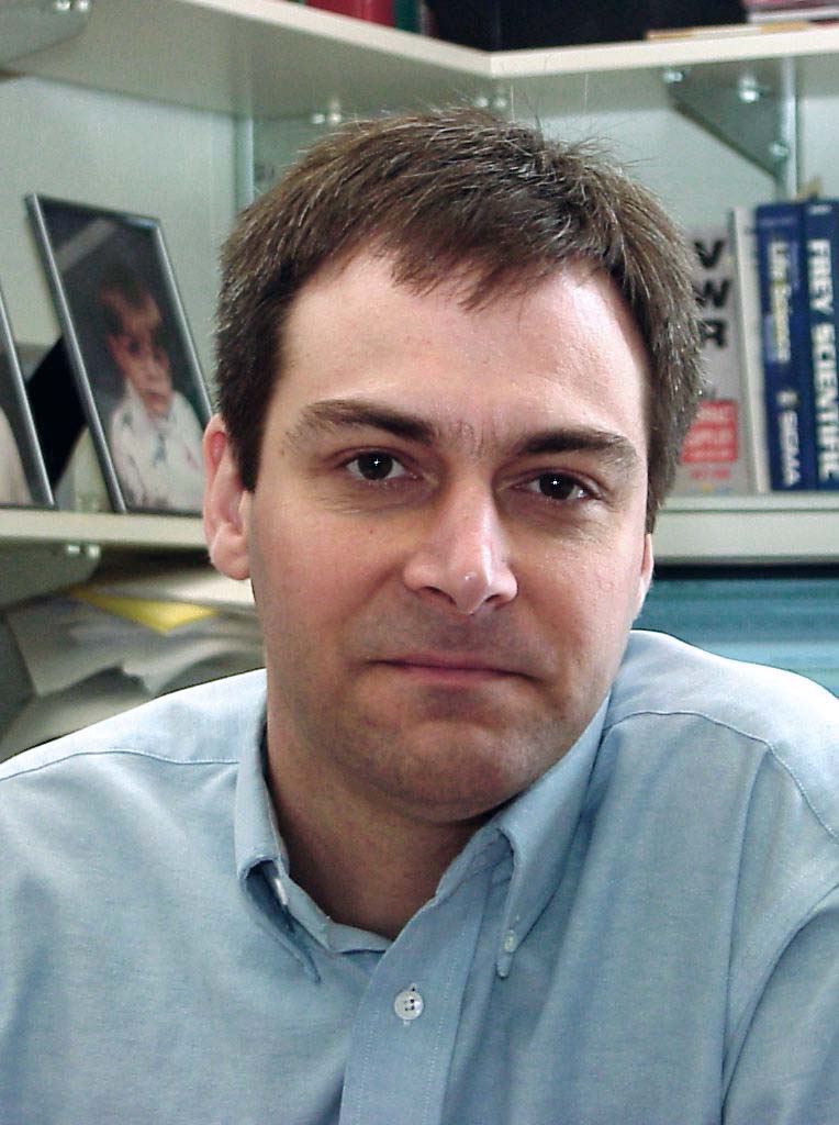 Headshot of Dr. Michael Calter wearing a blue shirt in his office.